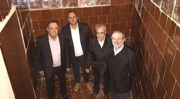 El regidor Francesc Mir, el president garriguenc Antoni Villas, el president de la Diputació Joan Reñé i l'alcalde Enric Mir dins d'un cub d'oli a Cal Gineret de les Borges