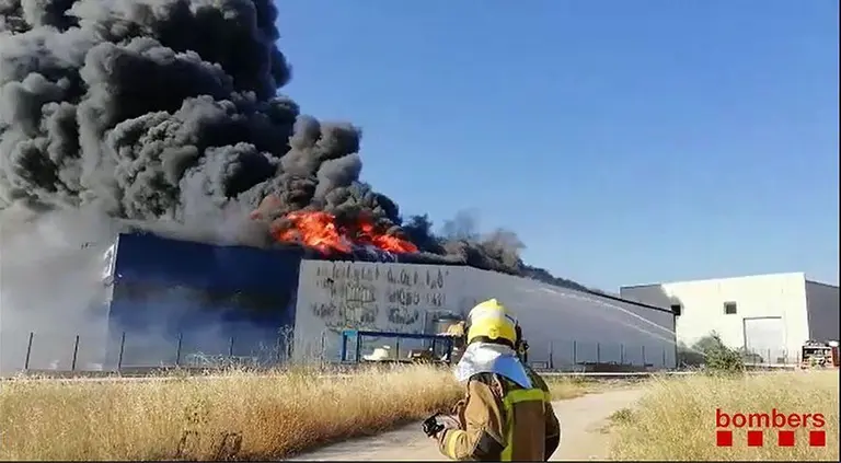 Un bomber observant les flames de la fàbrica de banyeres d'hidromassatge a Cervera