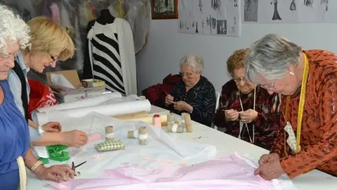 Les modistes del Museu de Vestits de paper preparen la rèplica de Caprile. 