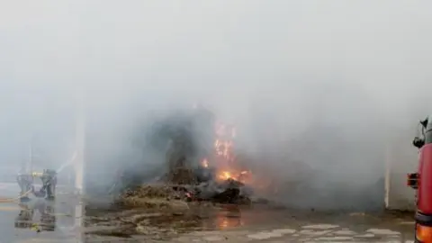 Els bombers van treballar per impedir que les flames es propaguessin a altres naus. 