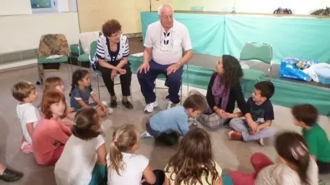 Els padrins han explicat com es juga al joc de les pedretes i han deixat que els infants practiquessin