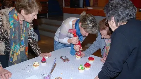 Yolanda Roca treballa amb les participants en el taller de Cupcakes a Sidamon.