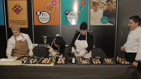 Alumnes de l'Escola d'Hoteleria preparen aperitius pel públic, a la Fira de L'Oli.