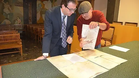 L'alcalde Marc Solsona i l'arxiver Josep Maria Cabau observen els docoments.