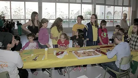 Els alumnes esperen les instruccions de les artesanes per confeccionar les galetes