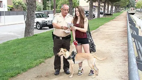 El guarda de terme informa de l'ordenança als propietaris d'animals.