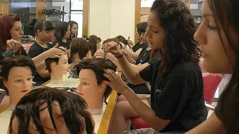 Les participants en la formació en els tallers de pràctiques en perruqueria.