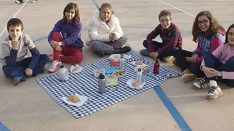 Els alumnes de l'escola La Bassa de Torregrossa preparen el berenar i el prenen al pati.