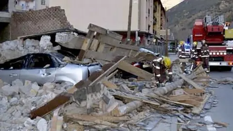 Imatge de l'edifici que s'ha desplomat i l'estat en què han quedat els vehicles.