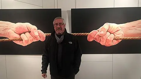 El pintor Sergio Bosque, davant d'un dels seus quadres exposats portada