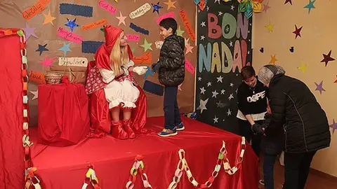 La vermelleta de Creu Roja lliura els regals als infants