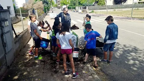 Els escolars planten arbres en el carrer  Clos d'Agramunt