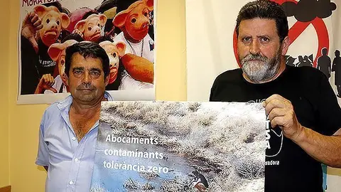El propietari del viver, Salvador Valls, i el portaveu dIpcena, Joan Vázquez, sostenen una foto de la bassa on suposadament saboquen residus de lempresa Tradired / Foto: Estela Busoms