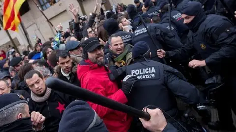 Un agent dels Mossos d'Esquadra aixeca una porra davant d'un dels manifestants contraris al trasllat de les obres del Museu de Lleida cap a Sixena, aquest 11 de desembre del 2017. (HORITZONTAL)