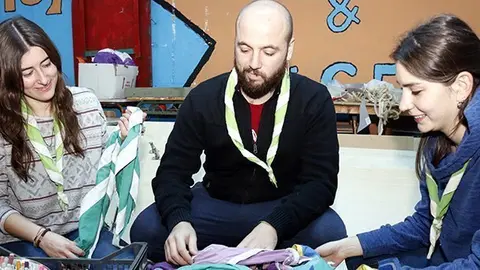 Pla mig on es poden veure tres caps de l'Agrupament Escolta de Bellpuig remenant foulards en una sala del local que es veuen obligats a deixar per no poder pagar el lloguer, el 9 de gener de 2018. (Horitzontal)