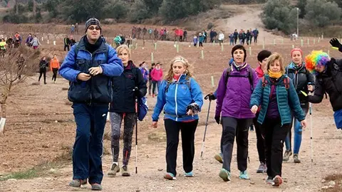Imatge general dels participants a la 4a Marxa de la Boira caminant enmig d'un camp de cultiu abans d'arribar a Mas Colom aquest 14 de gener del 2018 (horitzontal)