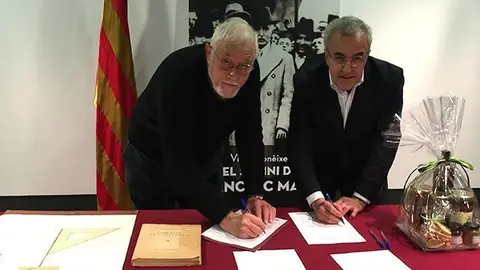Joan Bellmunt i Enric Mir signant el protocol de donació a l'Espai Macià de la litografia de Subirachs i el llibre sobre la població catalana del 1936