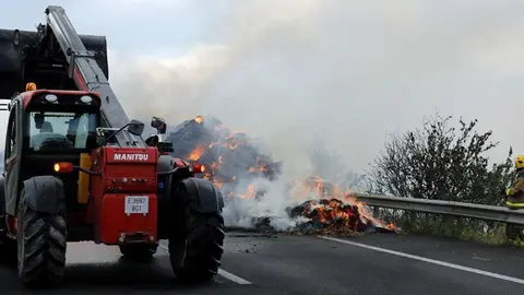 Els Bombers i una pala treballant per sufocar les flames de camió incendiat