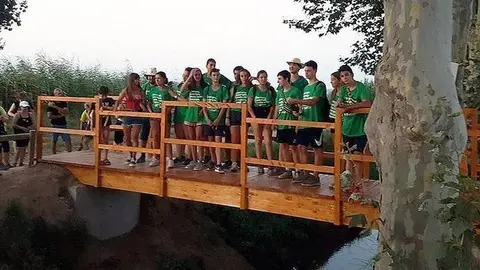 Els voluntaris del Camp de Treball sobre la passarel·la a Linyola