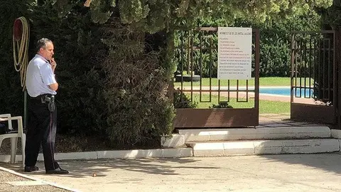 La porta del recinte de les piscines del Club Tennis Borges, custodiada per dos agents dels Mossos d’Esquadra