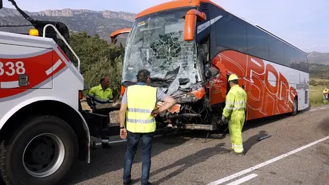 Pla obert on es pot veure l'autocar que ha impactat frontalment contra una furgoneta amb el resultat d'un mort a la C-12 a Àger mentre operaris i Bombers intenten retirar-lo de la via, el 21 de setembre de 2018. (Horitzontal)