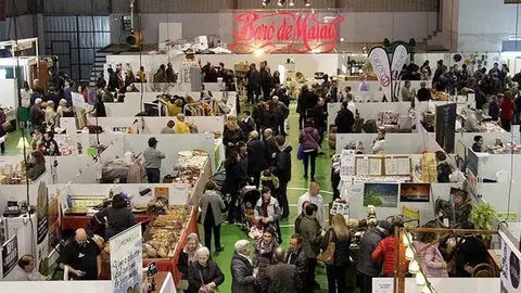 Pla general de les parades instal·lades a l'interior del pavelló de Maials, amb visitants recorrent els passadissos, en el marc de la 21a Fira de l'Oli Verd, el 18 de novembre de 2018 (Horitzontal).