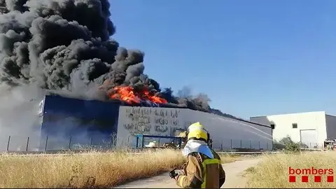 Un bomber observant les flames de la fàbrica de banyeres d'hidromassatge a Cervera