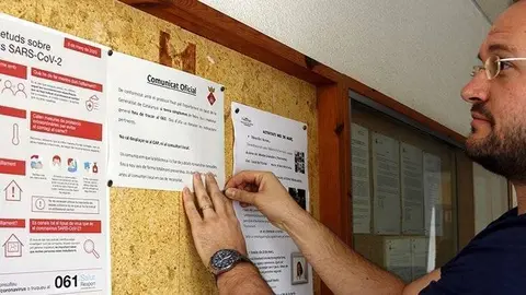 L'alcalde de Castellserà, Marcel Pujol, penjant un cartell informatiu sobre el coronavirus