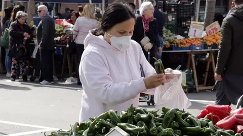 Pla mitjà d'una compradora amb mascareta al mercat dels dissabtes de Lleida, el 14 de març de 2020. (Horitzontal)