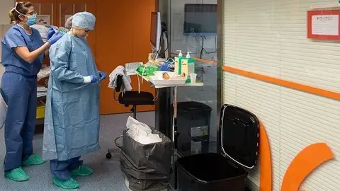 Una professional sanitària es protegeix abans d'entrar en una habitació