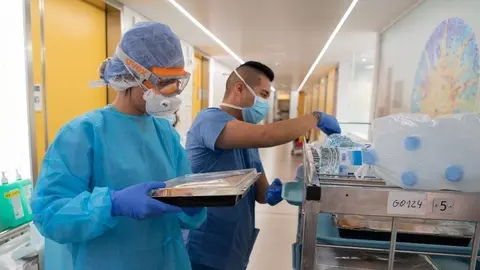 Professionals sanitaris entren el dinar a un malalt de coronavirus de l'Hospital Clínic. Publicada el 30 de març del 2020 (horitzontal)