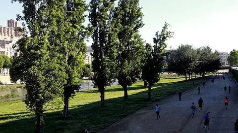 Esportistes i persones fent esport al passeig a la vora del riu Segre