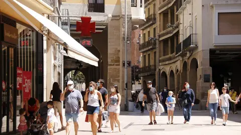 Pla general de diverses persones passejant amb mascareta per l'Eix Comercial de Lleida, a l'alçada de la plaça de la Paeria en el primer diumenge de rebaixes que coincideix amb el confinament perimetral del Segrià, el 5 de juliol de 2020 (Horitzotal).