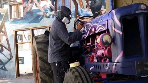 L'artista Zeso WF pintant un tractor en el GarGar de Penelles