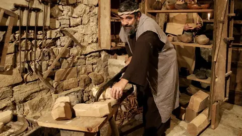 Pla obert d'una escena del Pessebre Vivent de Sant Guim de la Plana en què s'hi veu un home representant l'ofici d'escloper, el 22 de desembre de 2019. (Horitzontal)