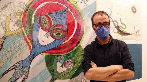 L'il·lustrador Carles Porta amb una de les imatges de l'Animac, a l'exposició al Museu Morera ©Territoris.cat
