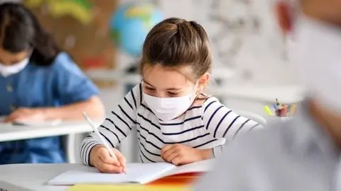 Grup d'escolars amb mascareta. Fotografia: iStock.