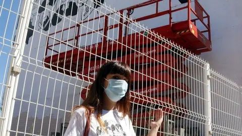 Pla mitjà de l'artista Cristina Dejuan mostrant el mural "censurat" que havia començat a fer Torrefarrera, el 30 d'agost de 2020 - Anna Berga