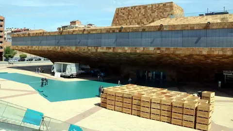 La plaça de la Llotja de Lleida es prepara per a la preestrena de la pel·lícula 'Alcarràs' amb un muntatge que inclou una gran catifa verda i elements per ambientar una explotació agrària ©Salvador Miret
