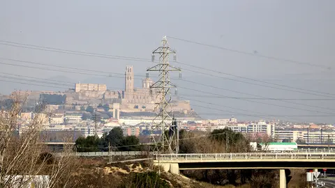 Pla obert on es poden veure diferents torres i línies d'alta tensió amb la Seu Vella de Lleida al fons, des d'Albatàrrec, l'11 de gener de 2022. (Horitzontal)