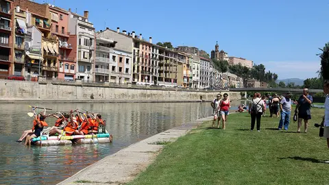 Una barca de la Petita Transsegre baixa pel riu Segre davant l'atenta mirada del públic que s'ha aplegat al parc de la Transsegre de Balaguer. Foto: ACN