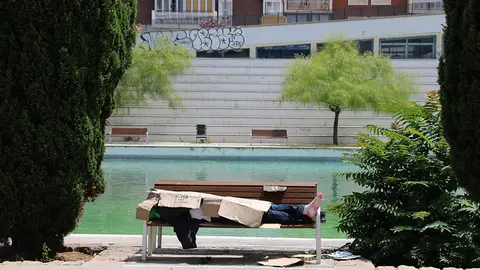 Una persona sense sostre protegint-se de la calor amb cartrons - Foto: Norma Vidal