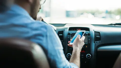 transportation concept - man using phone while driving the car