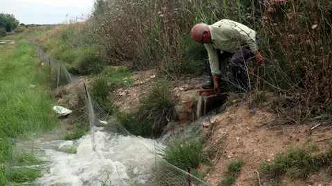 El productor Albert Capdevila aixeca la pala de reg en una finca de pomeres que té a Puiggròs, a les Garrigues - Foto: Anna Berga