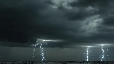 A mezocyclone lightning storm with dark clouds forming over the plains in Tornado Alley, Oklahoma at night