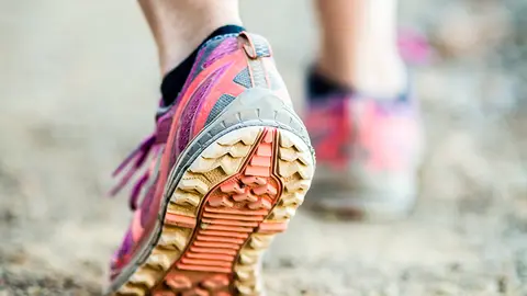 Walking or running legs on trail, adventure and exercising in mountains nature, dirt road