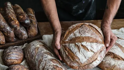 Un forner sosté un pa de pagès