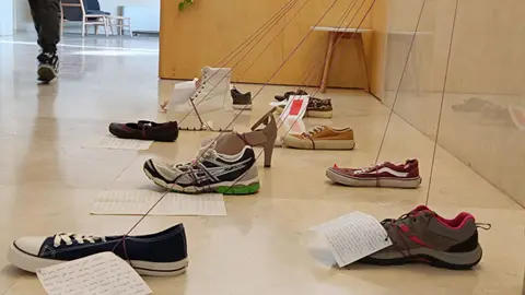 Una instal·lació de sabates i petits textos de vida de membres de la comunitat universitària que han patit violència masclista acompanya el Punt Lila, situat al vestíbul del centre - Foto: Òscar Godoy-UdL