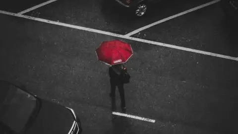 Persona caminant sota la pluja. Foto: Pexels