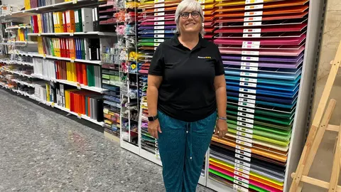 Encarregada de l'Abacus, Sandra Quer davant d'unes cartolines a la tenda Abacus. Foto: Oriol Almacellas